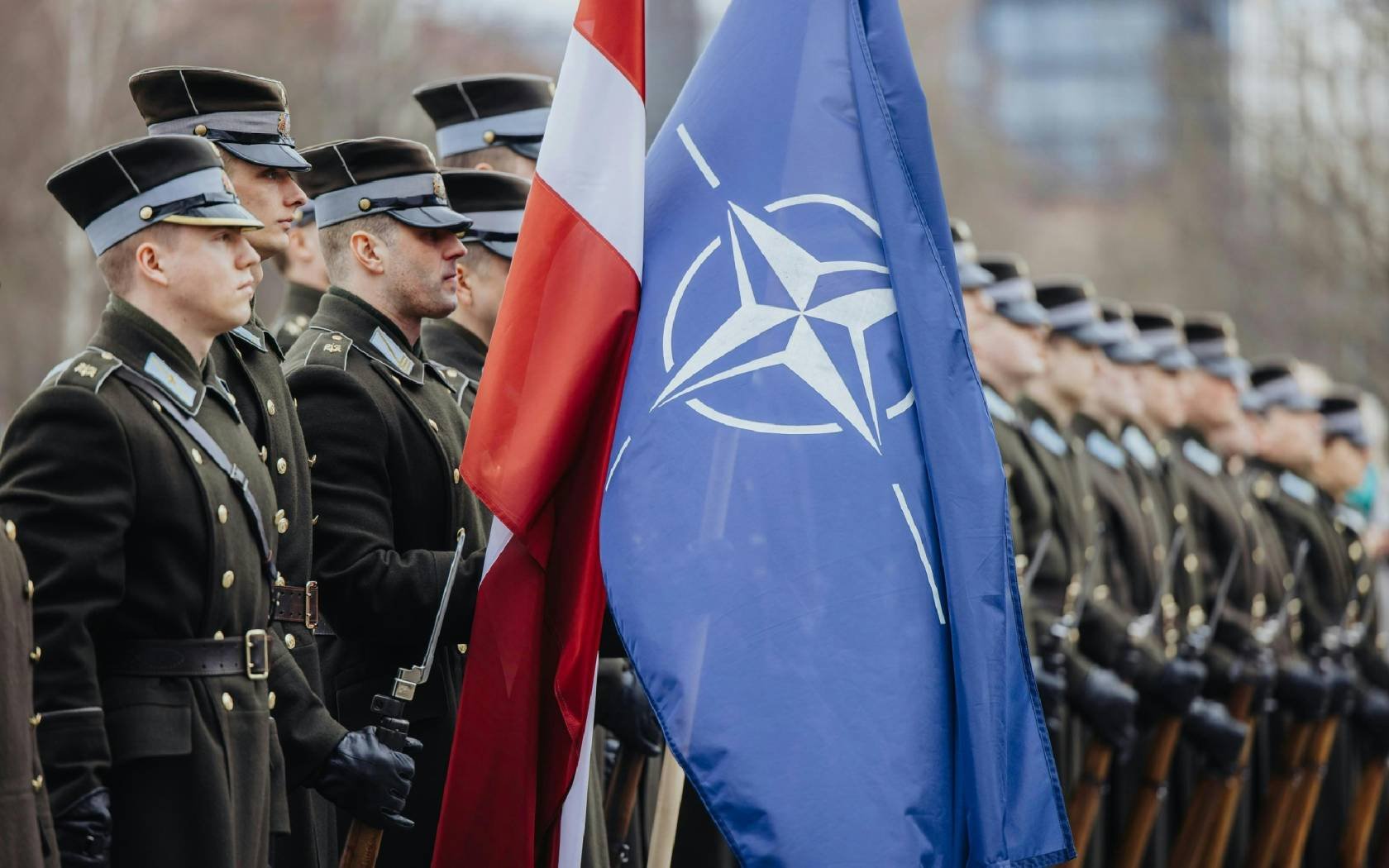 Latvian soldiers with the Latvian and the NATO flag.