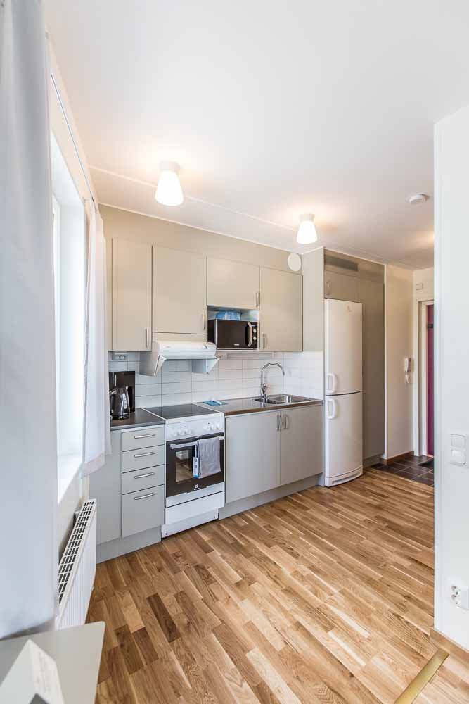 Kitchen with stove, oven, cupboards, refrigerator, freezer, microwave and sink.