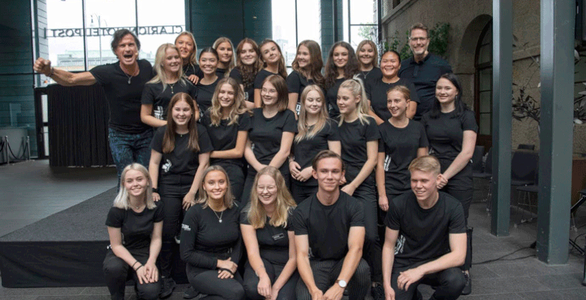 Petter Stordalen jublar tillsammans med  Realgymnasiets elever och grundaren Jan Vikström (längst upp till höger), över att hotellutbildningen har blivit en succé.  