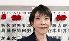 Japanese Prime Minister Sanae Takaichi poses for photos as she attaches a rosette to the name of a Liberal Democratic Party candidate.