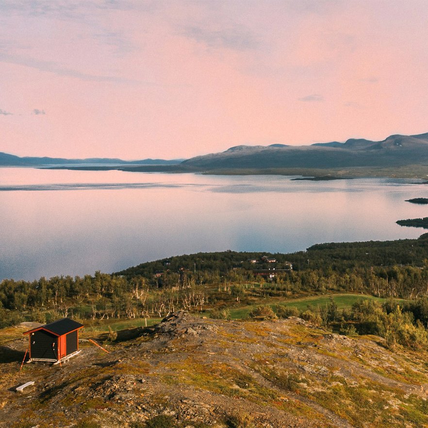 utsiktsstugan sommartid med en rosaf&auml;rgad himmel och ett spegelblankt Tornetr&auml;sk