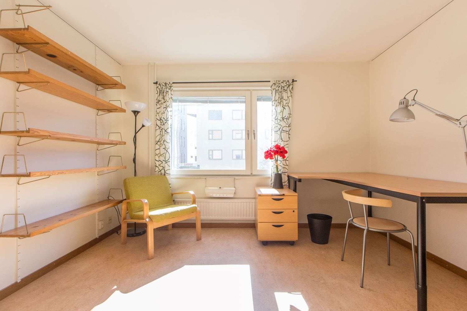 Studentroom with desk, chair, desk drawers, book shelfs and armchair.