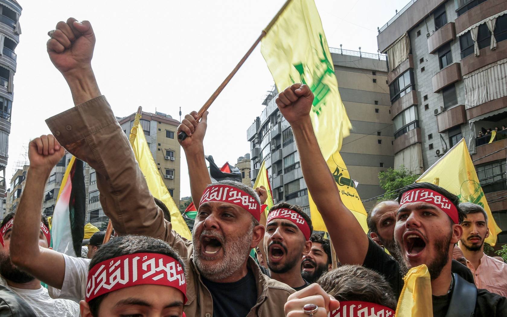 Lebanese protesters carry Hizbollah flags in Beirut.