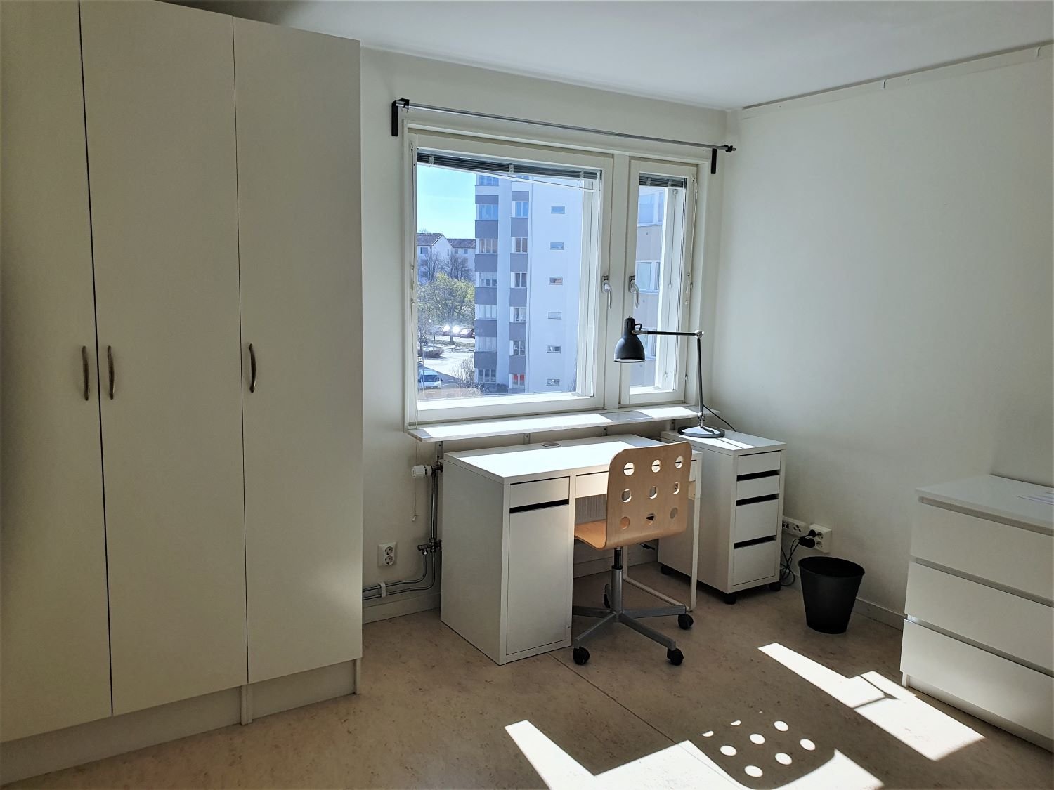 Student room with wardrobes, desk, chair and chest of drawers.
