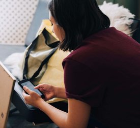 Woman using mobile phone while sitting in new home