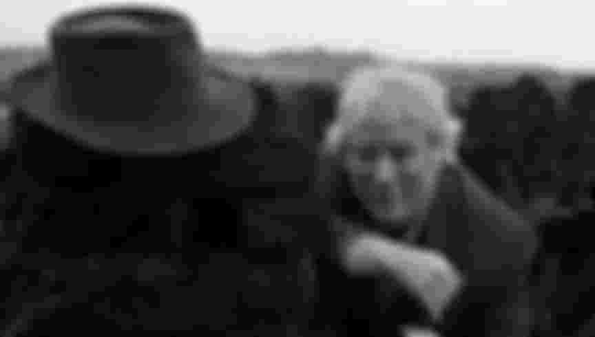 Seamus Heaney at a turf bog in Bellaghy wearing his father's coat, hat and walking stick and additional shots in the Bellaghy bog, 1986. Bobbie Hanvey, photographer. Image bh002815, Bobbie Hanvey Photographic Archives, John J. Burns Library, Boston College.