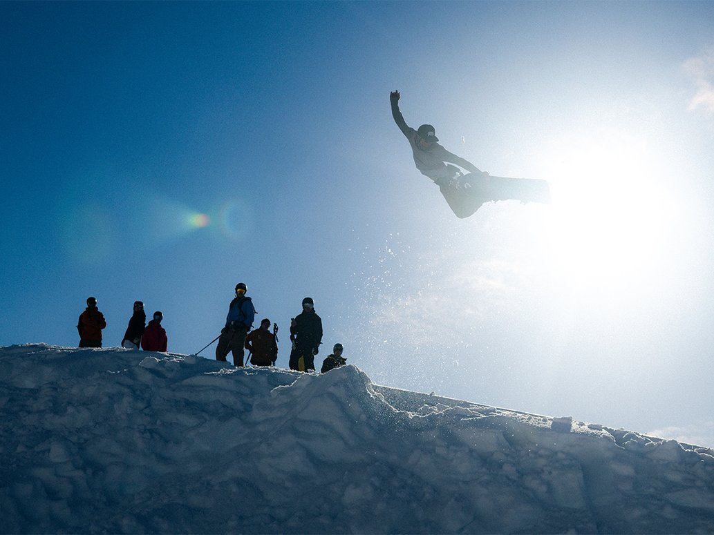 ett stort hopp med snowboard i Riksgr&auml;nsen med solen i bakgrunden
