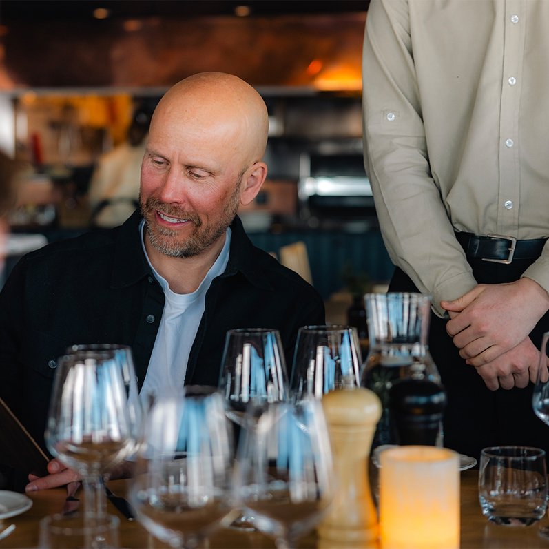 en man l&auml;ser menyn i restaurang Lapporten