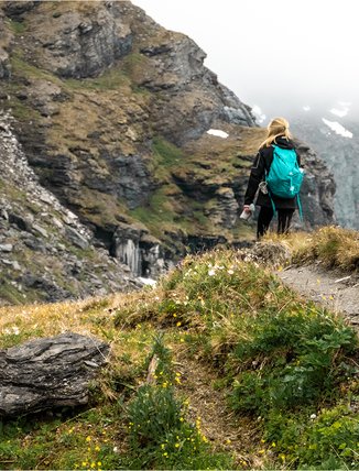 Kvinna p&aring; en stig i stendalen K&auml;rkevagge