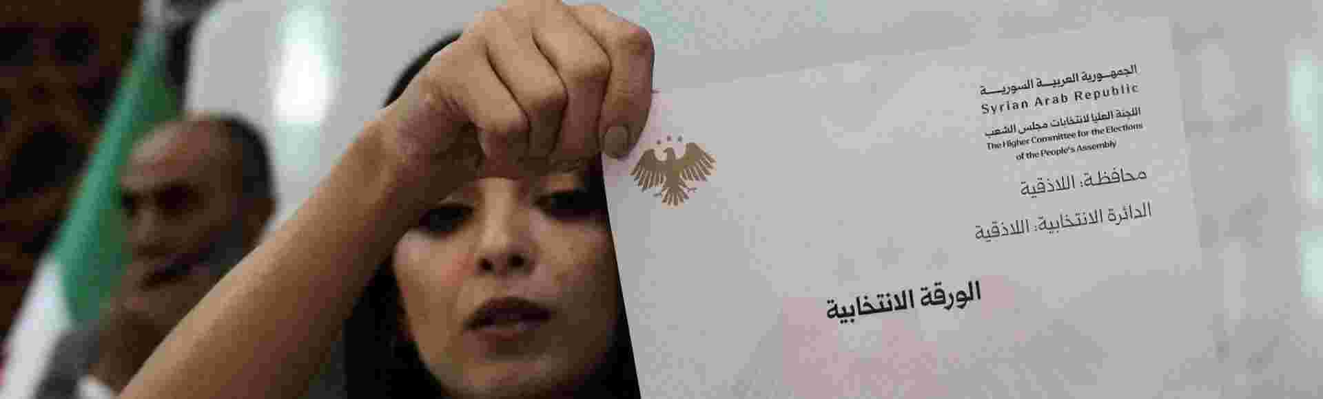 A Syrian election official shows a ballot paper during the counting of ballots in Latakia, Syria, on Sunday, 5 October, 2025.