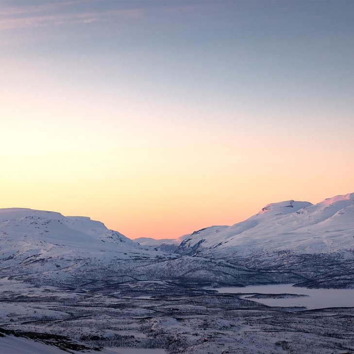 pastellf&auml;rgad himmel ovan fj&auml;lltopparna under slutet av polarnatten
