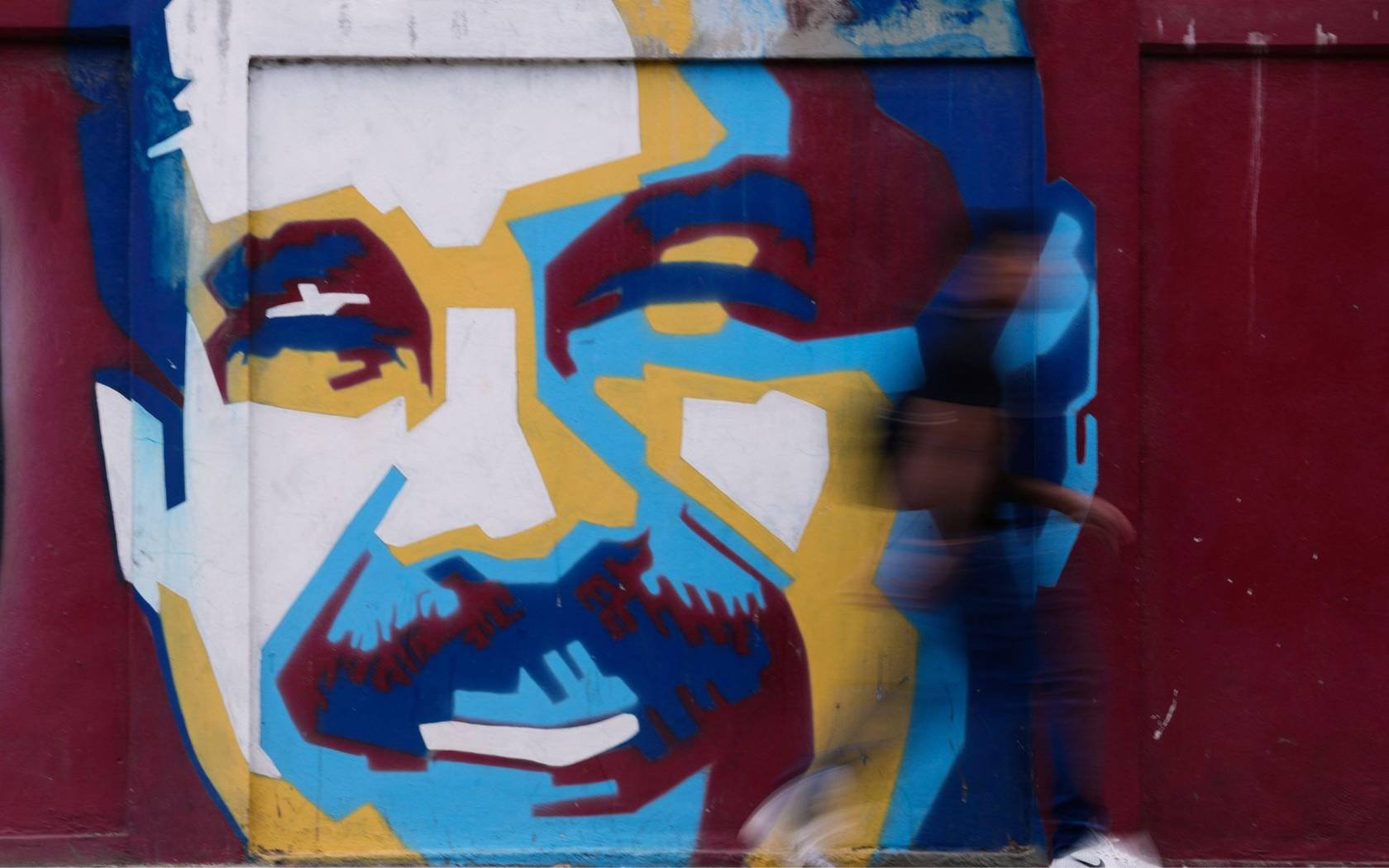 A pedestrian walks past a mural of Venezuelan President Nicolas Maduro Sunday, 4 January, 2026.