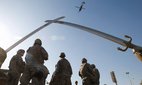 US soldiers wait before going out on a mission under the Crossed-Sabers – a towering 160-tonne, bronze monument of two crossed swords held in Saddam's hands, at the fortified Green Zone in Baghdad, December 7, 2008.