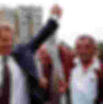 British Prime Minister Tony Blair greets an ethnic Albanian by holding up his hand in central Pristina, Yugoslavia during a one-day visit Saturday July 31, 1999. It was Blair's first visit to Kosovo since NATO's bombing campaign against Yugoslavia. (Photo by David Brauchli)