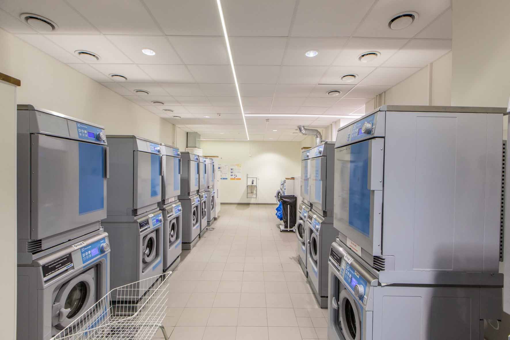 Laundry room with several washing machines and dryers.