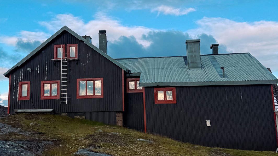Låktatjåkko fjällstations baksida med blå himmel och moln