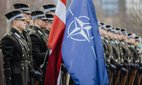 Latvian soldiers with the Latvian and the NATO flag.