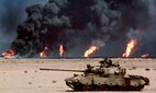 An abandoned Russian-made T-62 tank in the desert in front of burning oil wells in Kuwait, in February-March 1991.