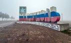 Mariupol's city sign painted in the colours of the Russian flag.