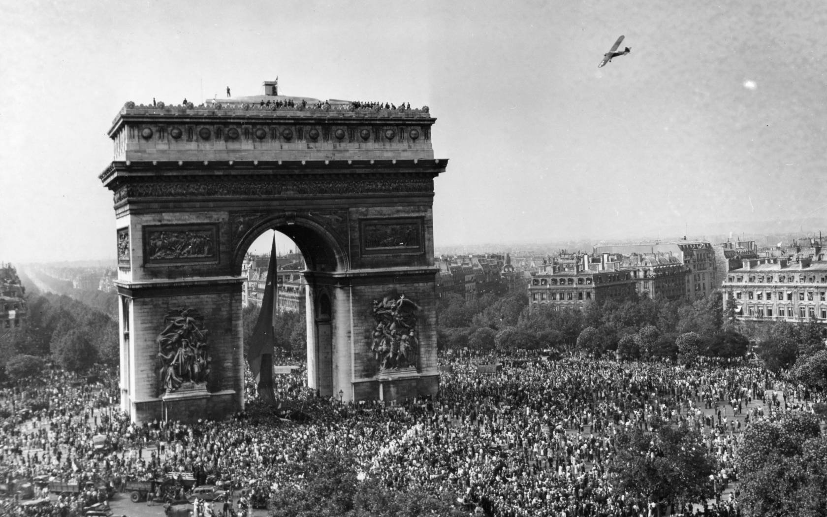 Parisians gather around the Arc de Triomphe as Allied forces liberate the city. Credit: RBM Vintage Images / Alamy Stock Photo.