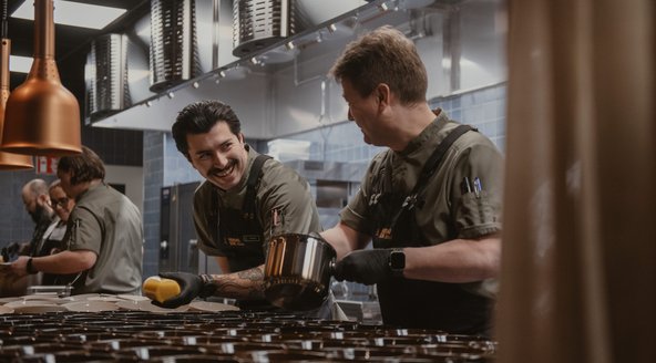 Kockar i köket som lägger upp mat