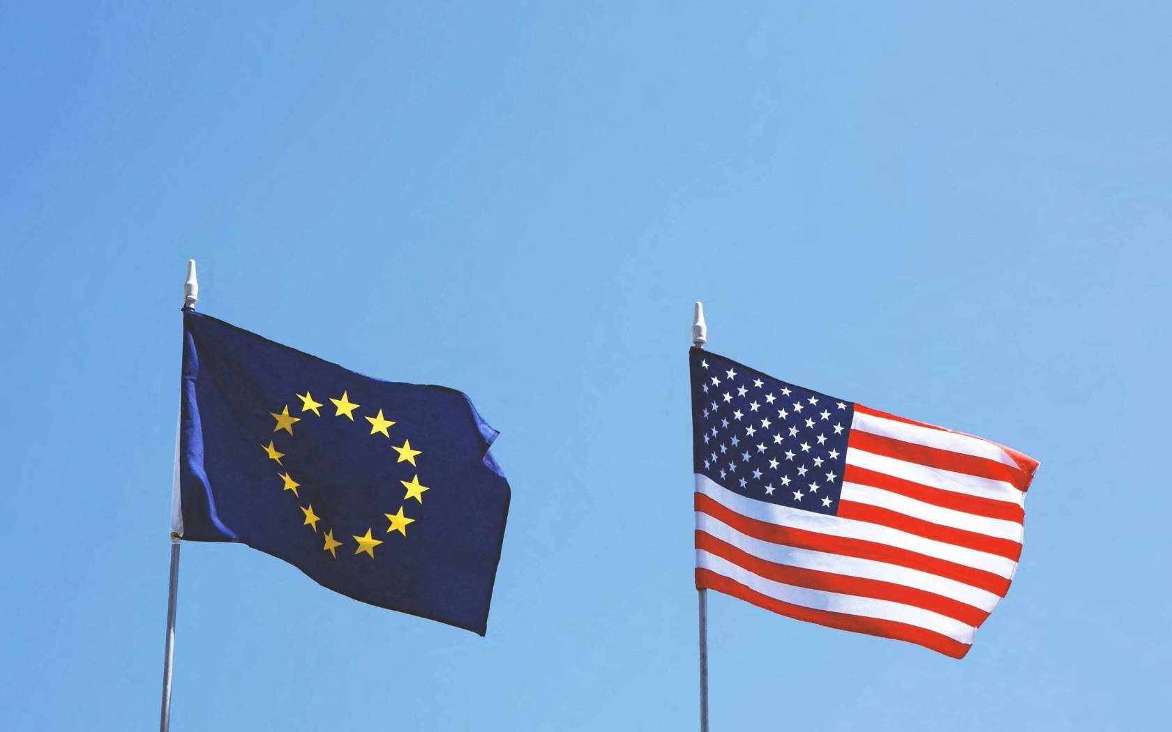 The flags of the European Union and the United States of America flying next to each other.