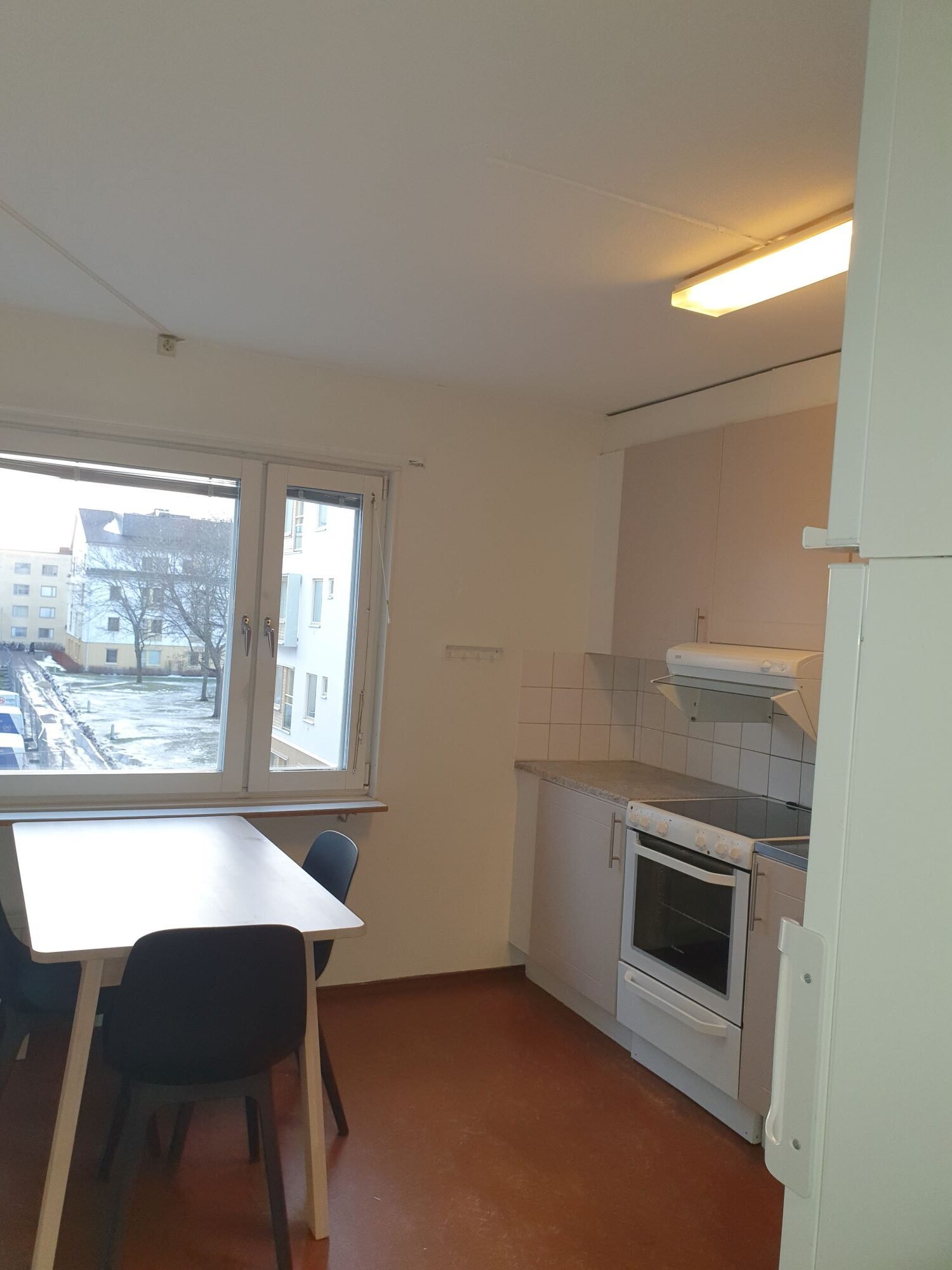 Common kitchen with stove, oven, refrigerator, freezer, table and chairs.