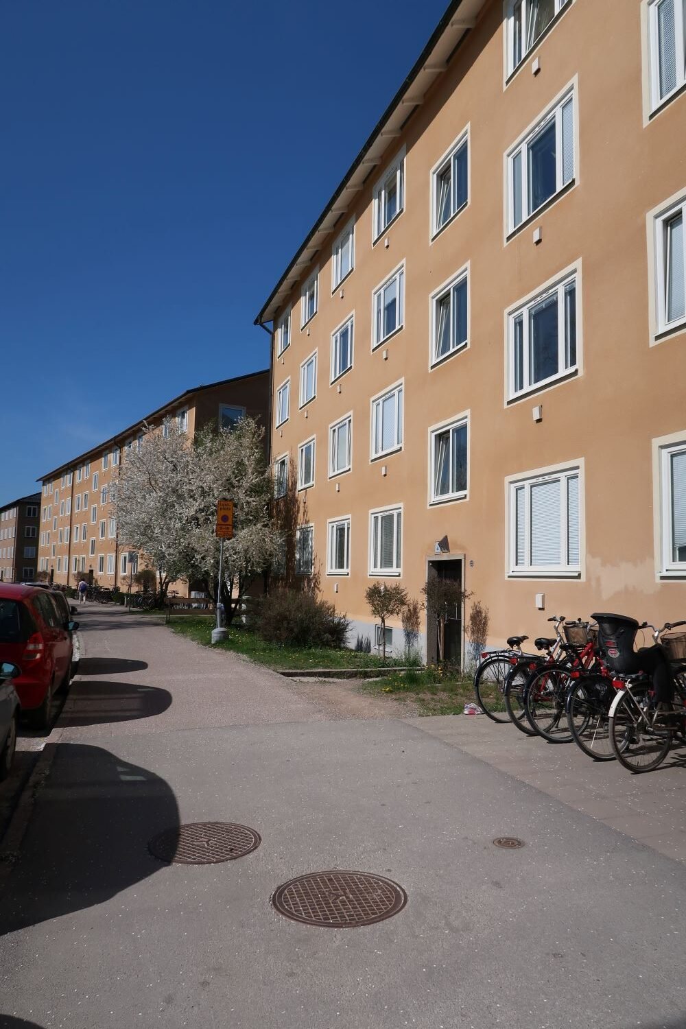 Exterior of beige 4-story building with bicycle parking outside.