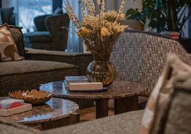 En av loungegrupperna på plan två med soffor, fåtöljer och blommor på borden.