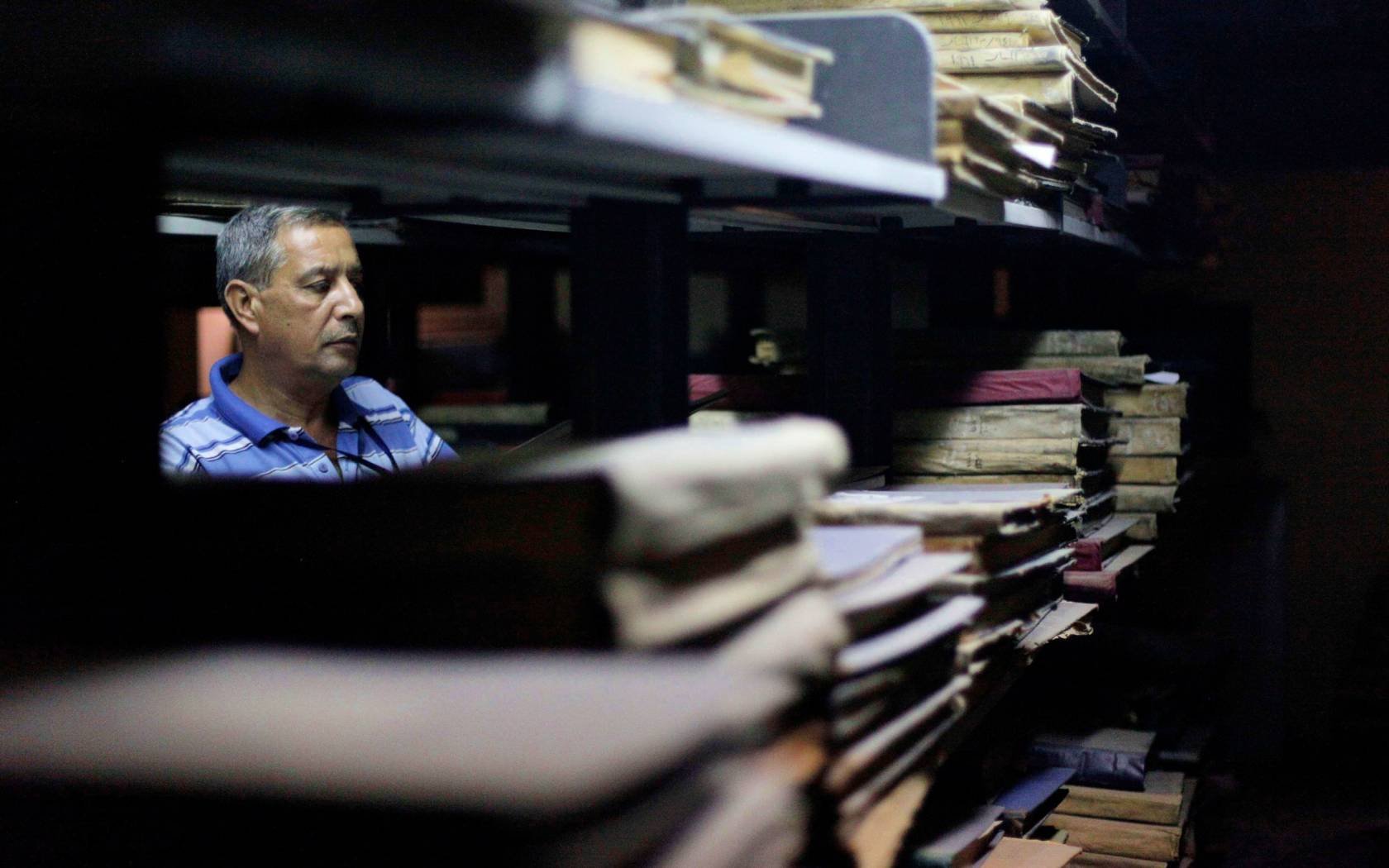 An archivist checks books and documents at the Iraq National Library and Archives in Baghdad.
